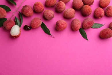 Fresh ripe lychees with leaves on pink background, flat lay. Space for text