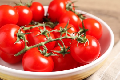 Photo of Fresh cherry tomatoes in bowl on table, closeup