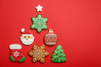 Different tasty Christmas cookies on red background, flat lay. Space for text