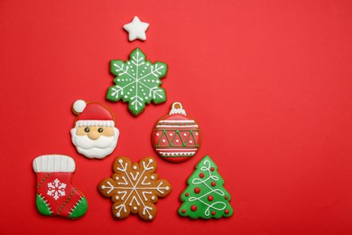 Photo of Different tasty Christmas cookies on red background, flat lay. Space for text