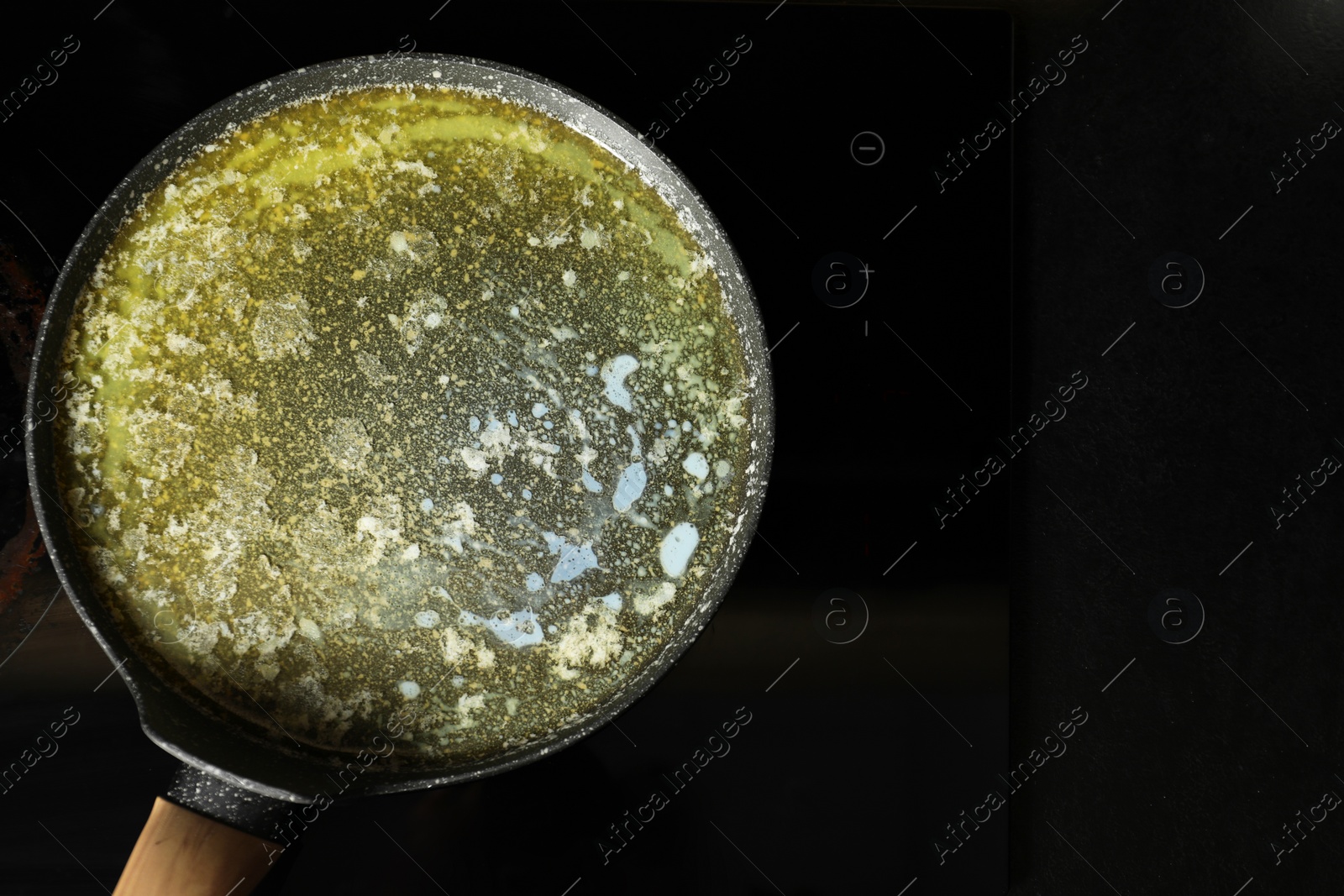 Photo of Melted butter in frying pan on cooktop, top view. Space for text