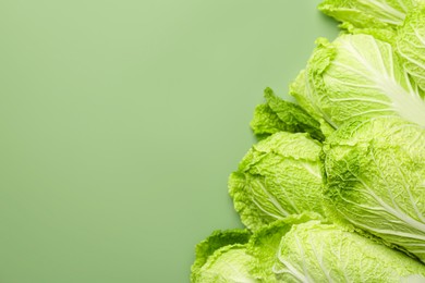 Photo of Many fresh Chinese cabbages on pale green background, top view. Space for text