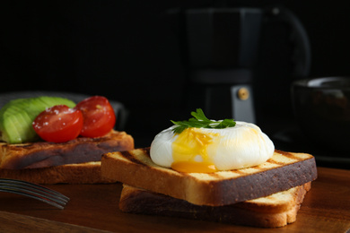 Delicious poached egg with toasted bread served on wooden board