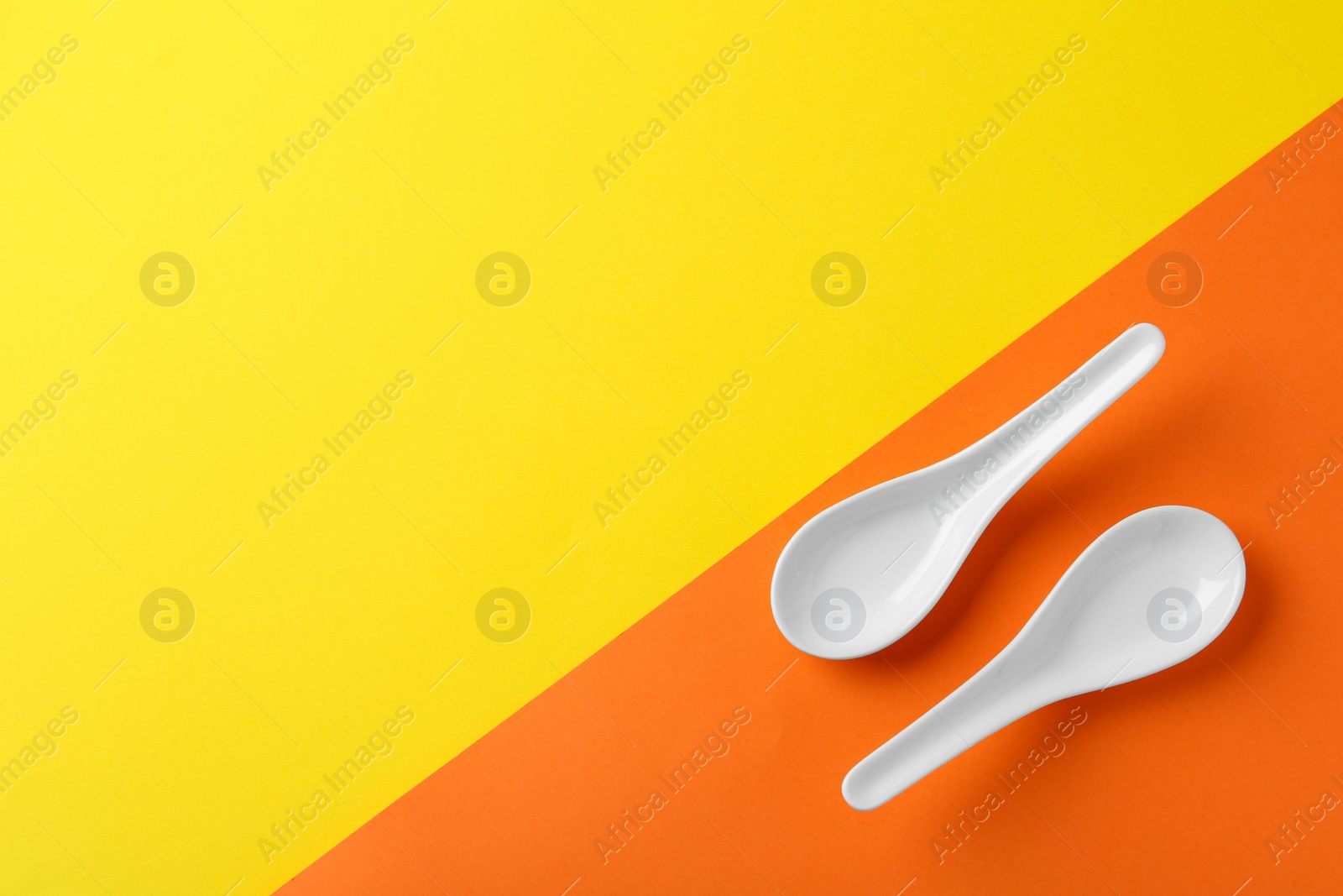 Photo of Miso soup spoons on color background, flat lay. Space for text