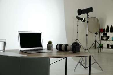 Photo studio interior with set of professional equipment and workplace