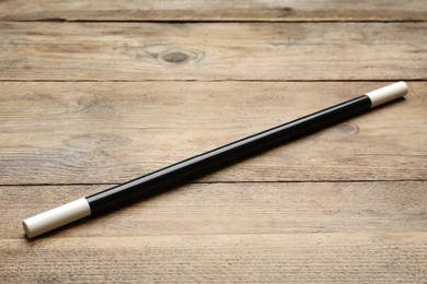 Photo of Beautiful black magic wand on wooden table
