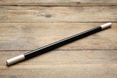 Beautiful black magic wand on wooden table