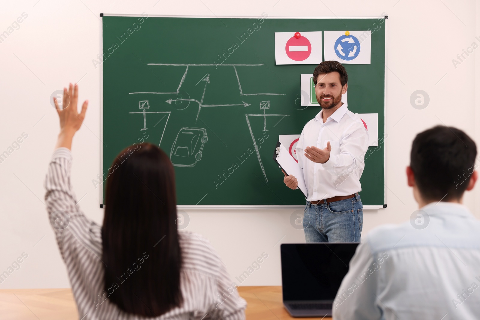 Photo of Teacher giving lesson to audience in driving school