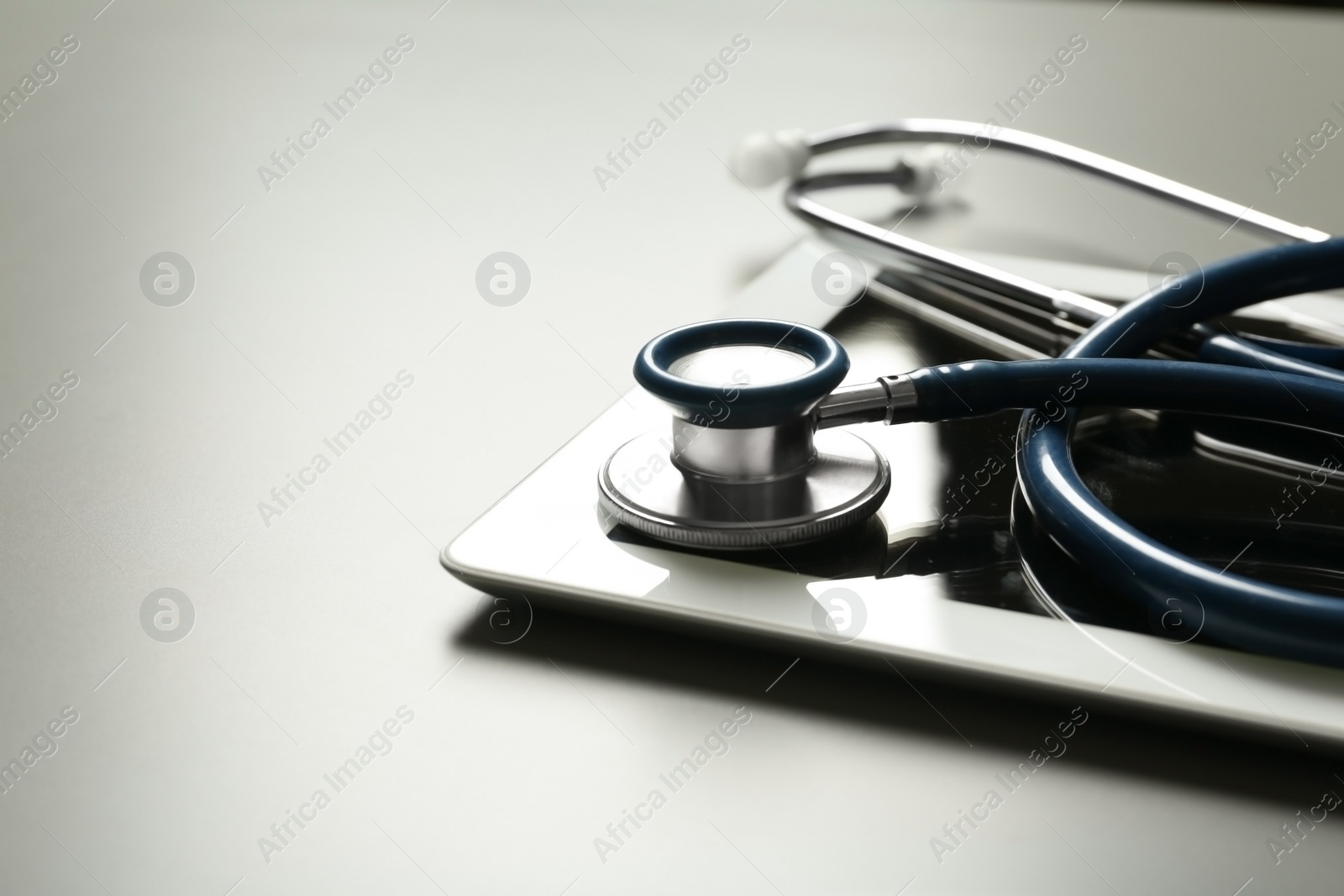 Photo of Stethoscope and tablet on table, space for text. Medical students stuff