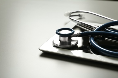 Stethoscope and tablet on table, space for text. Medical students stuff