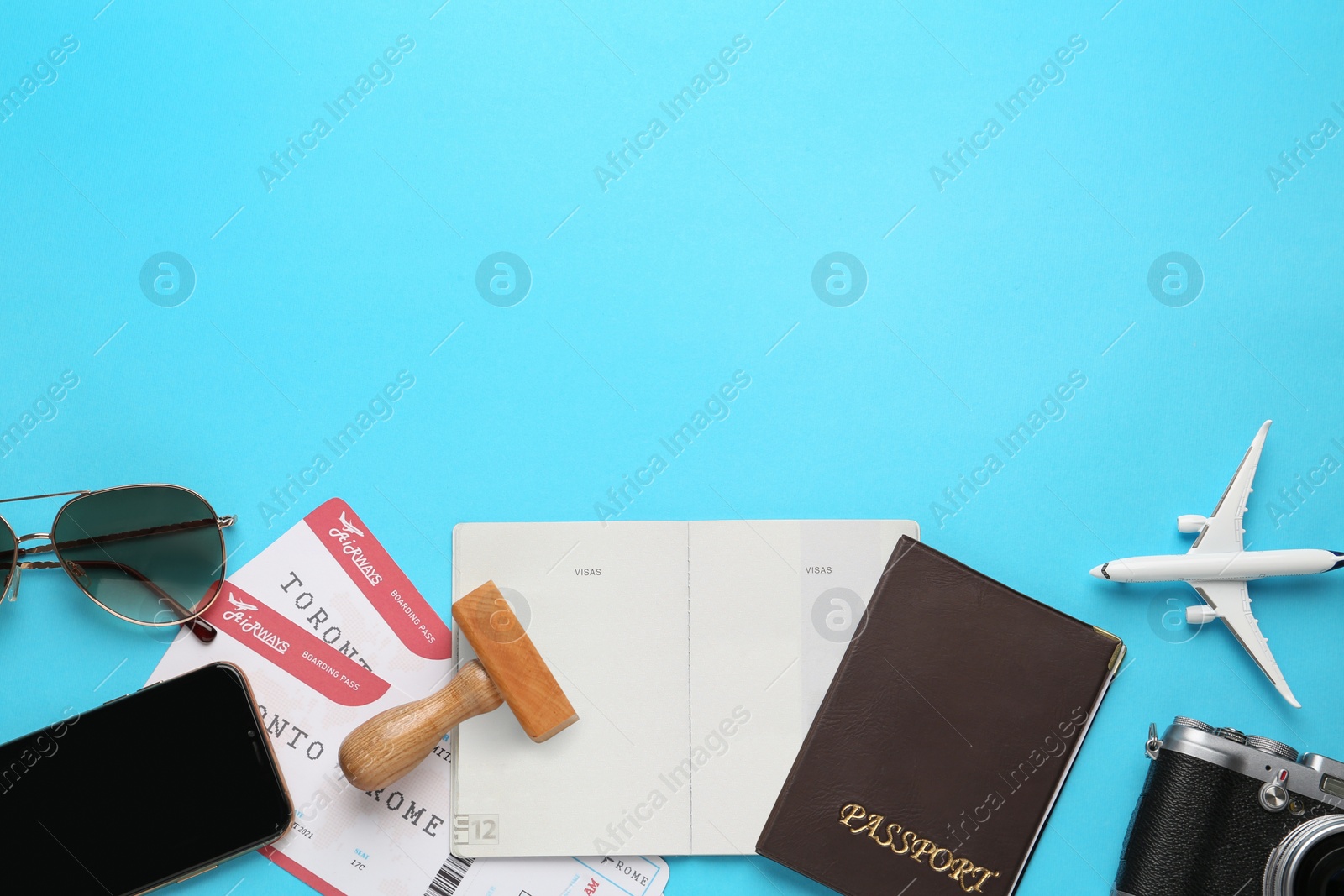 Photo of Flat lay composition with passports, stamp and flight tickets on light blue background, space for text