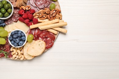 Photo of Tasty parmesan cheese and other different appetizers on white wooden table, top view. Space for text