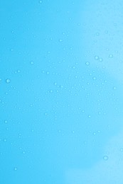 Photo of Water drops on light blue background, top view