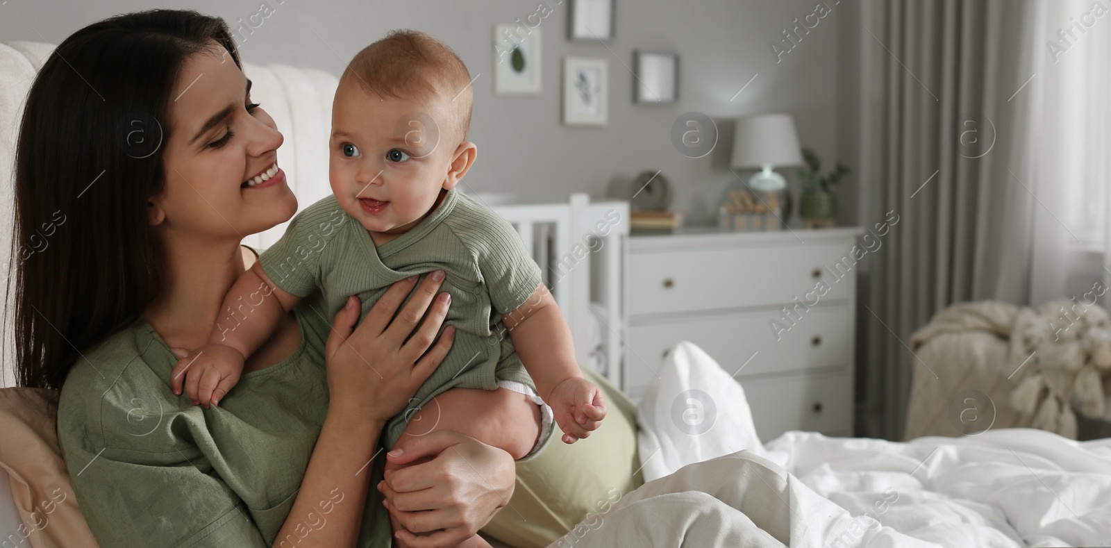 Image of Happy young mother with her cute baby at home, space for text. Banner design 