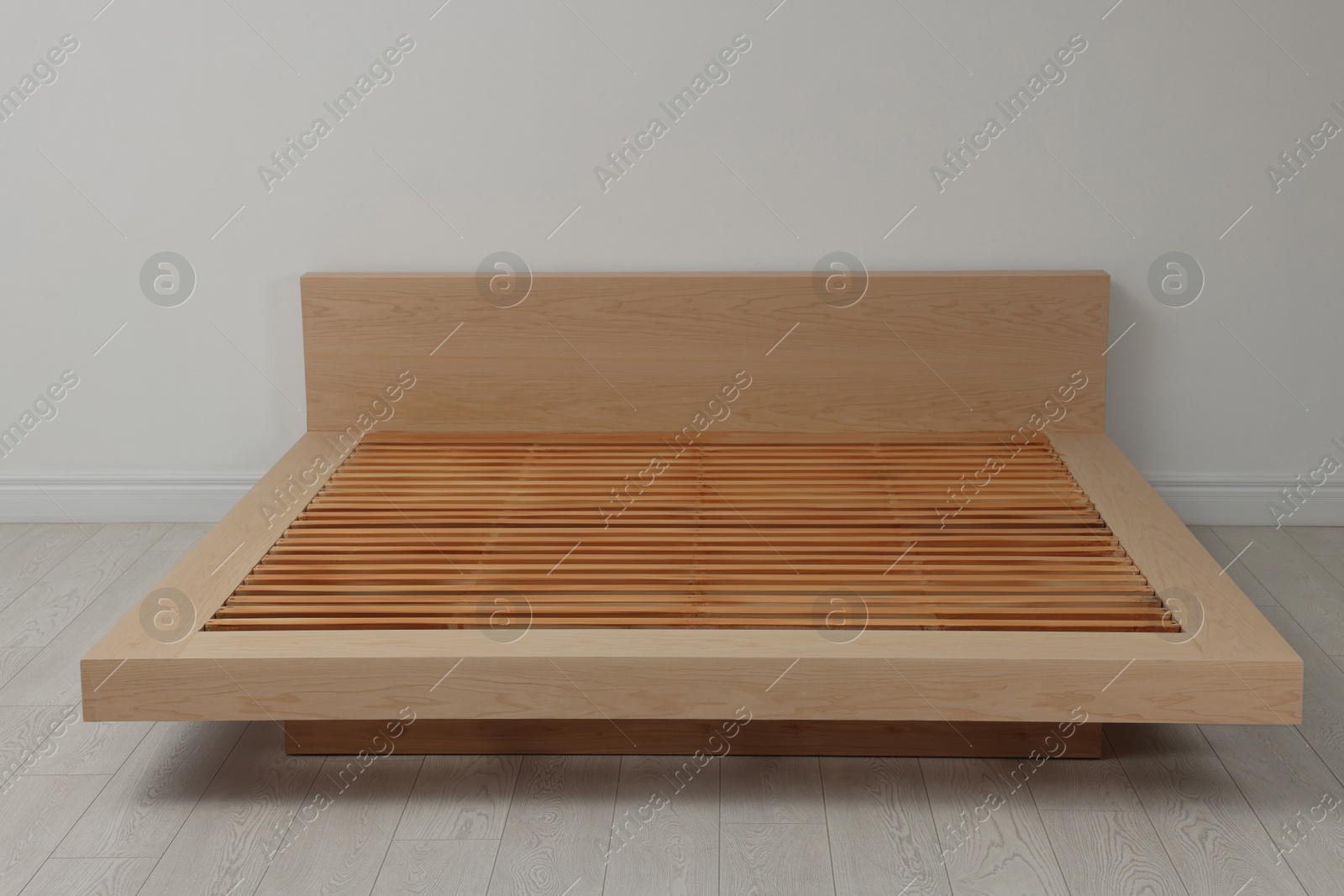 Photo of New wooden bed frame in empty room