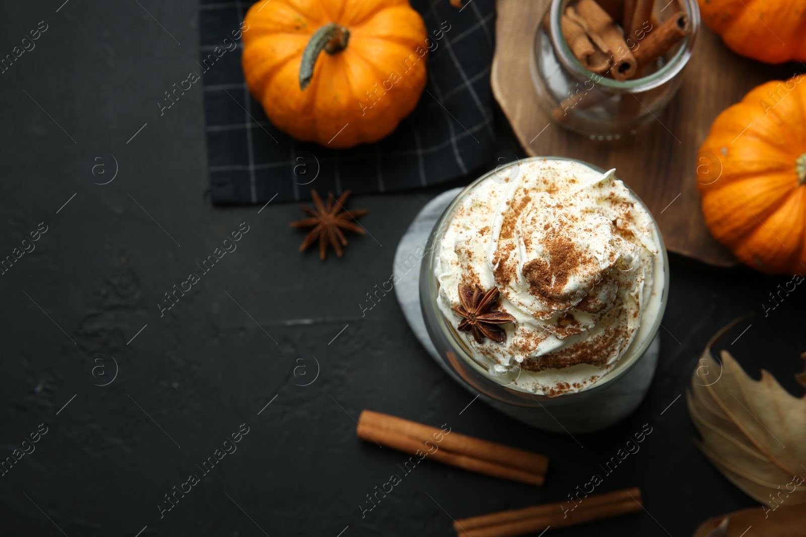 Photo of Flat lay composition with glass of pumpkin spice latte on black table. Space for text