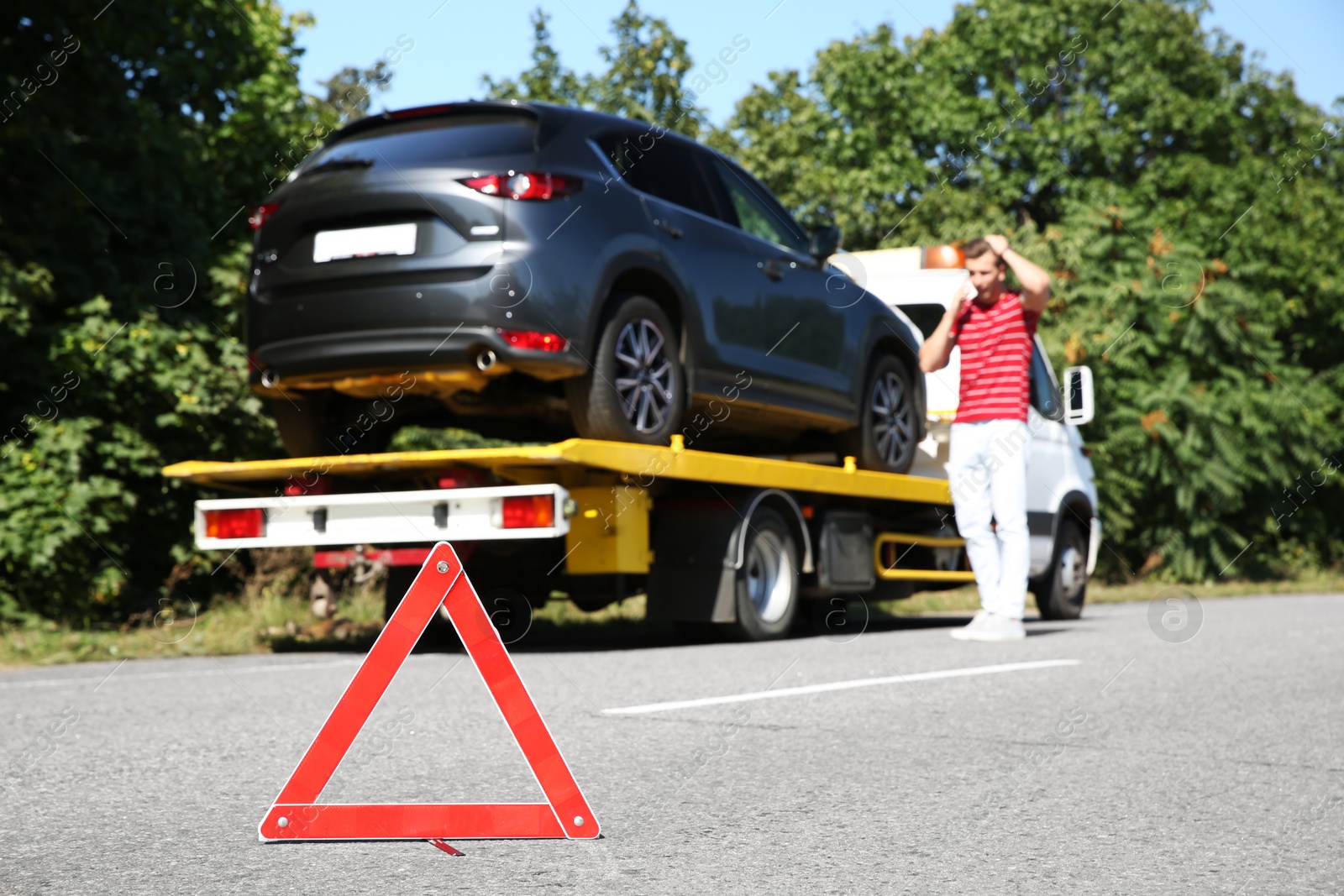 Photo of Emergency stop sign and man near broken car on background