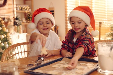 Photo of Cute little children making delicious Christmas cookies at home