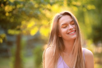 Beautiful young woman posing outdoors on sunny day