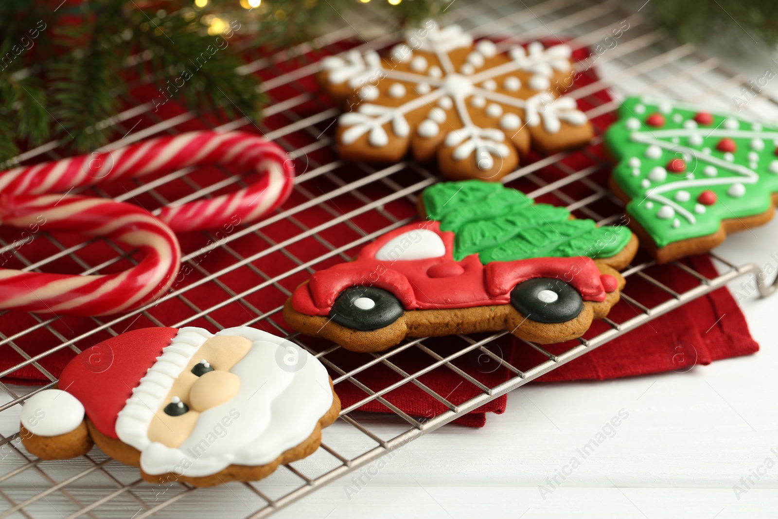 Photo of Tasty homemade Christmas cookies and candy canes on white wooden table, closeup