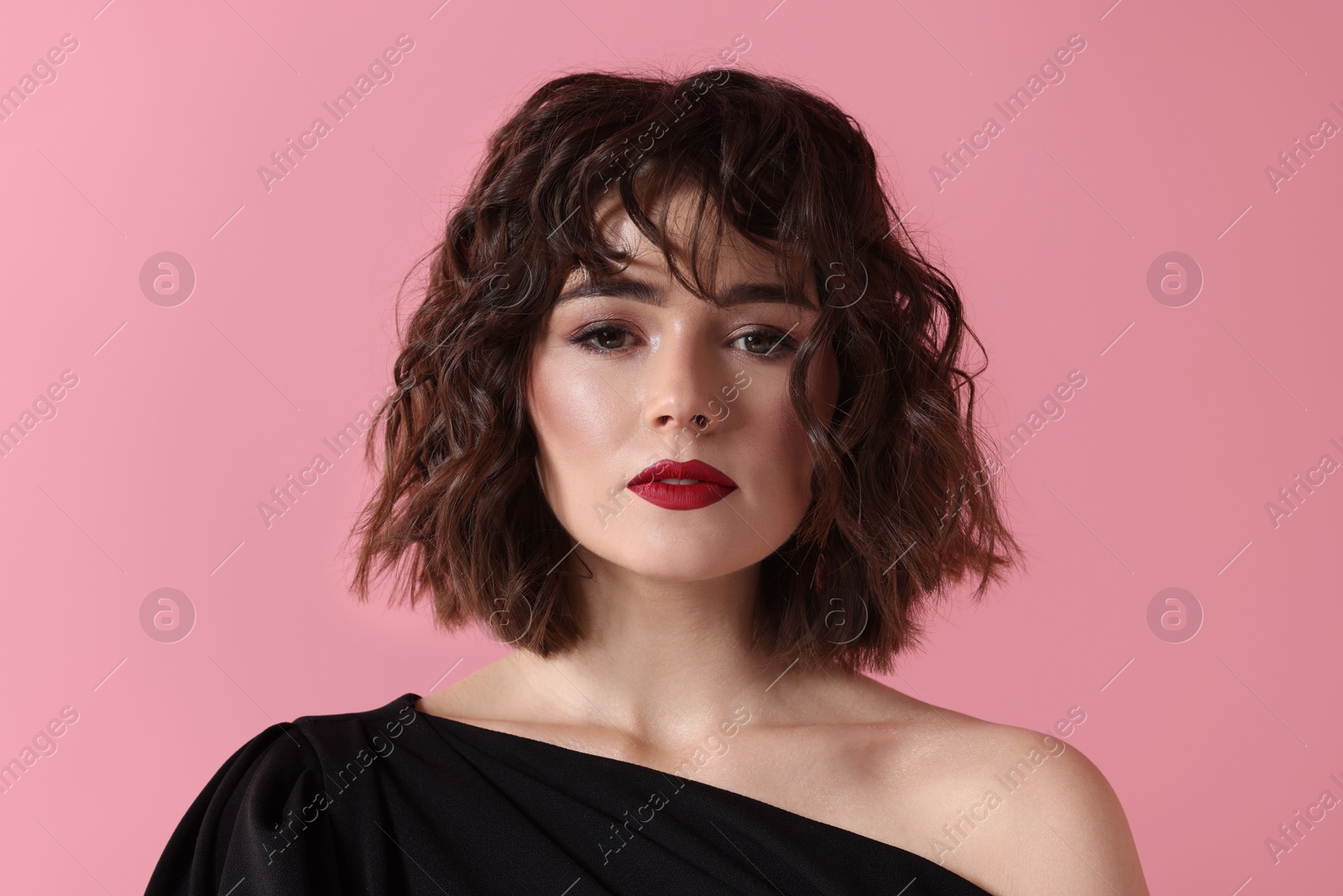 Photo of Portrait of beautiful young woman with wavy hairstyle on pink background