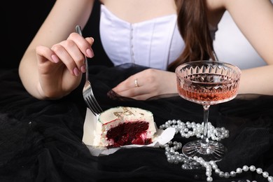 Photo of Fashionable photo of woman eating her Birthday cake on black background, closeup