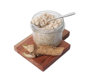 Photo of Wooden board with glass jar of tasty prepared horseradish, spoon and root isolated on white