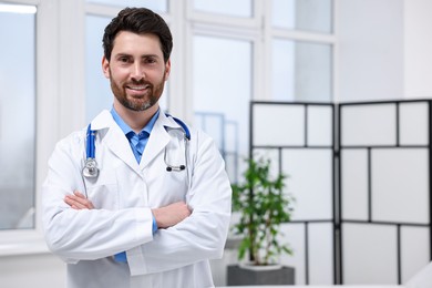 Medical consultant with stethoscope in clinic, space for text