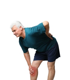 Portrait of senior man having knee problems on grey background