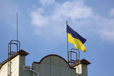 Photo of Ukrainian flag on building against blue sky
