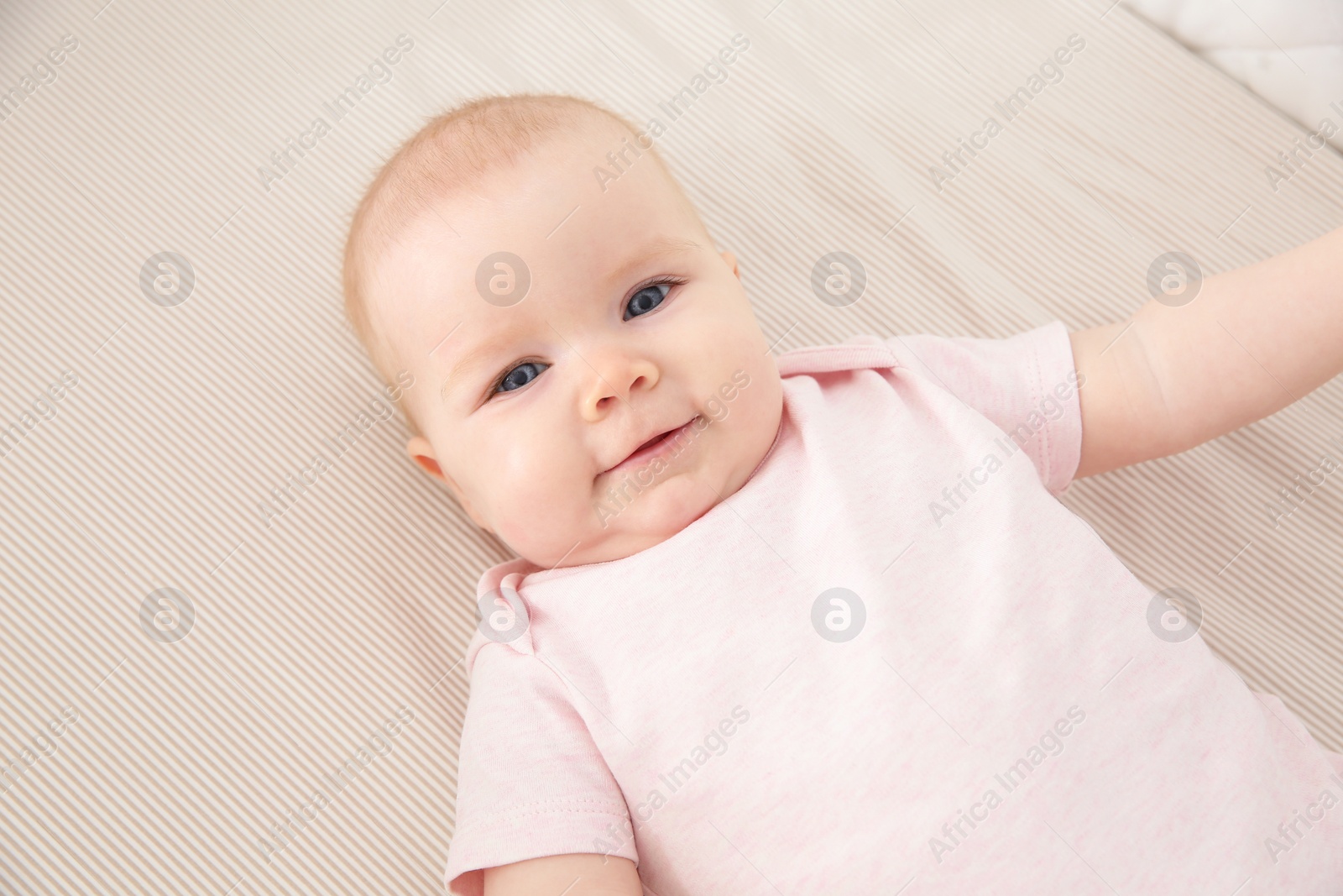 Photo of Cute baby girl in crib. Bedtime schedule