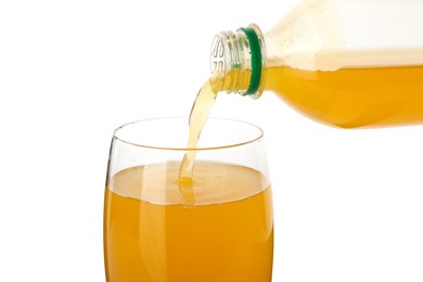 Pouring delicious orange soda water from bottle into glass on white background