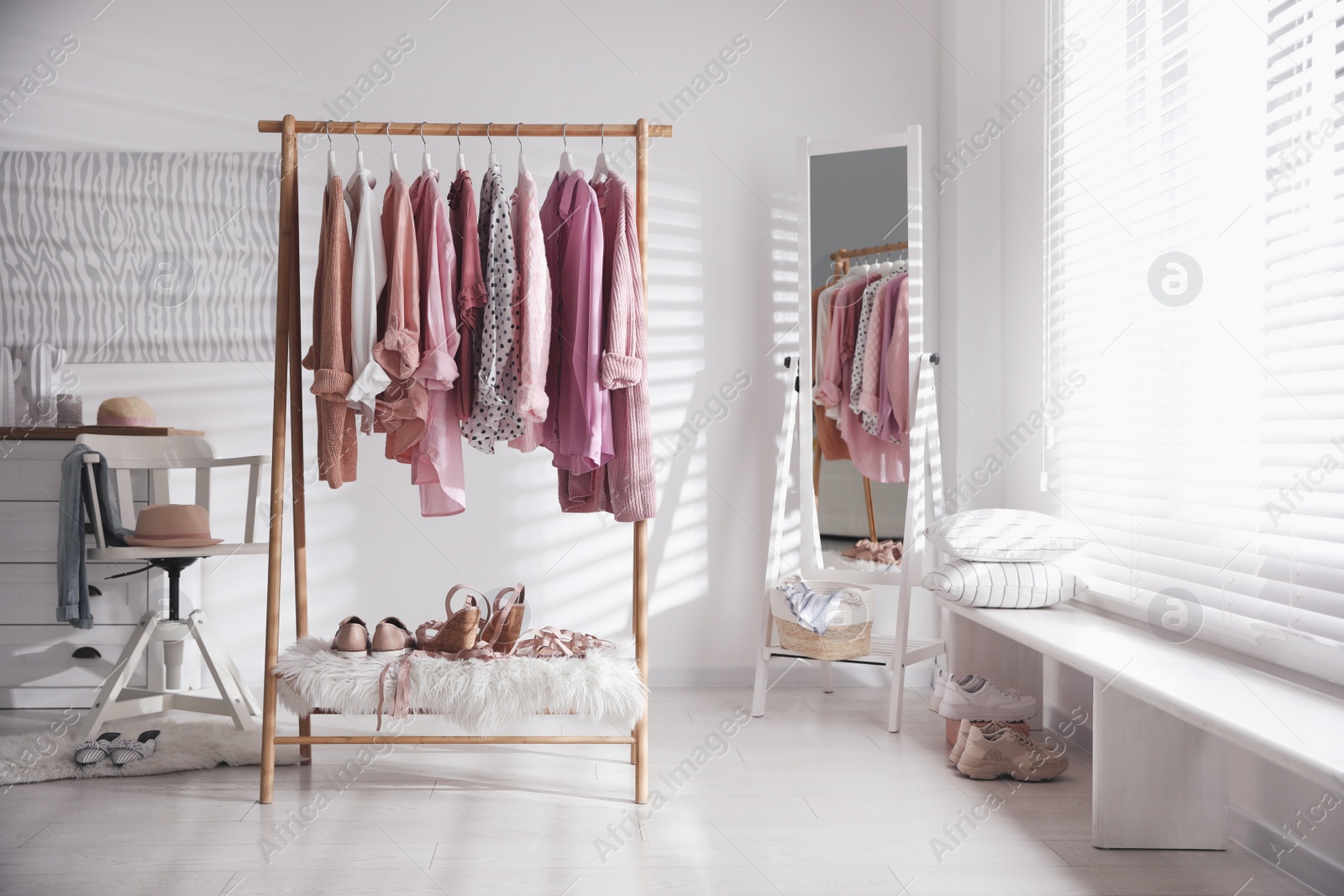 Photo of Rack with stylish women's clothes indoors. Interior design