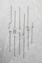 Photo of Set of different logopedic probes on marble table, flat lay. Speech therapist's tools