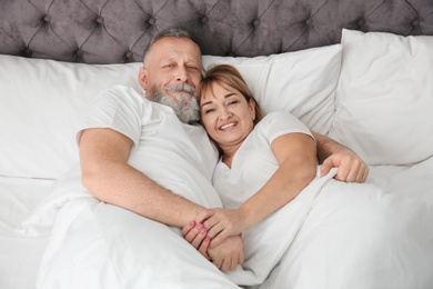 Mature couple together in bed at home