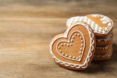 Photo of Tasty heart shaped gingerbread cookies on wooden table, closeup. Space for text