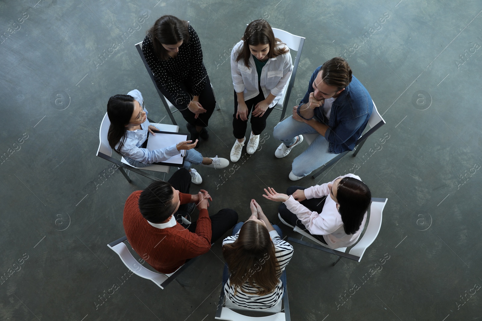 Photo of Psychotherapist working with patients in group therapy session, top view