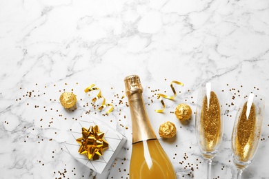 Photo of Flat lay composition with bottle of champagne for celebration on white marble background. Space for text