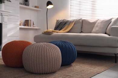 Stylish comfortable poufs near sofa in room. Home design