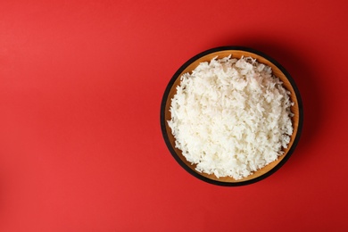 Photo of Bowl of boiled rice on color background, top view with space for text