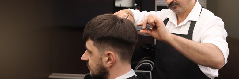 Image of Professional hairdresser cutting man's hair in barbershop. Banner design