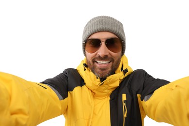 Smiling man in hat and sunglasses taking selfie on white background