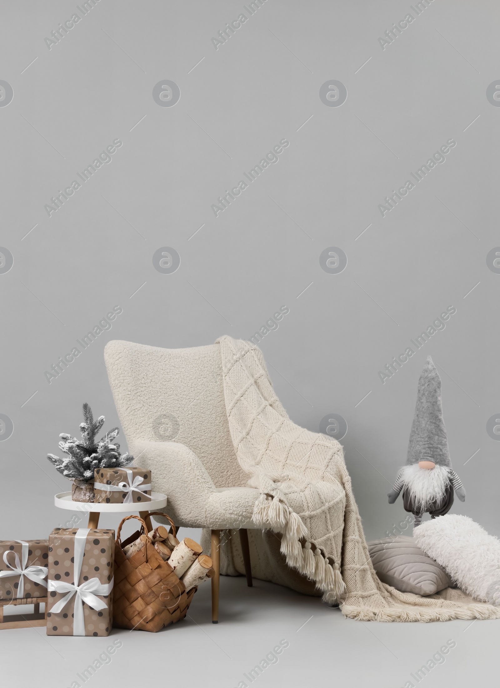 Photo of Stylish photo zone with armchair and Christmas decor in professional studio