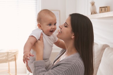 Photo of Happy young mother with her cute baby in living room