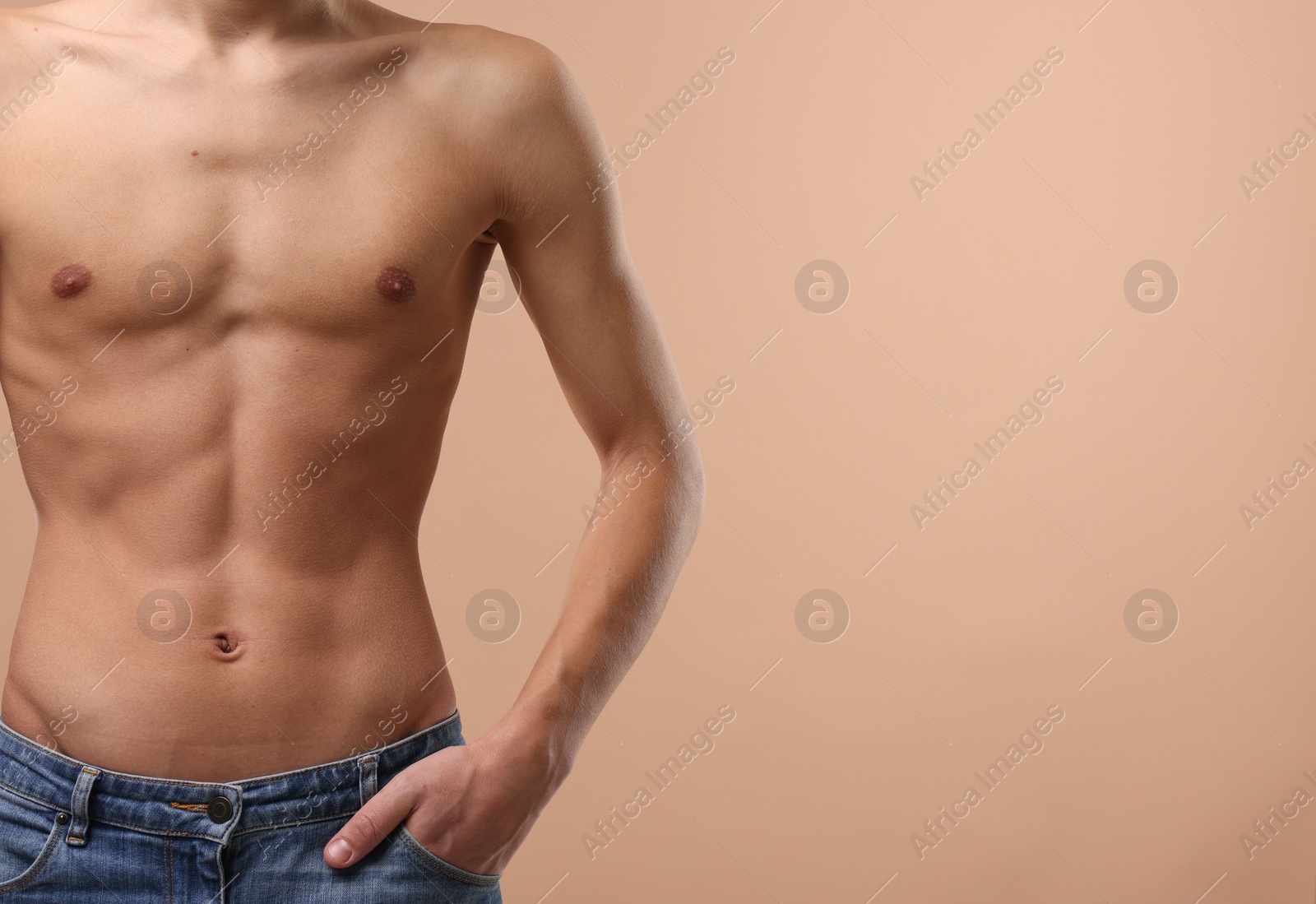 Photo of Shirtless man with slim body on beige background, closeup. Space for text