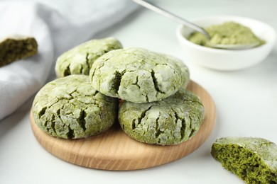 Board with tasty matcha cookies on white table, closeup