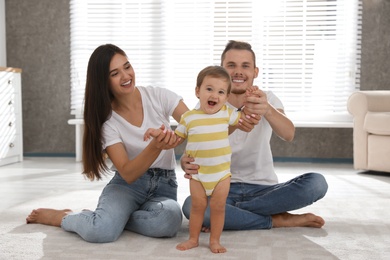 Photo of Happy family with adorable little baby at home