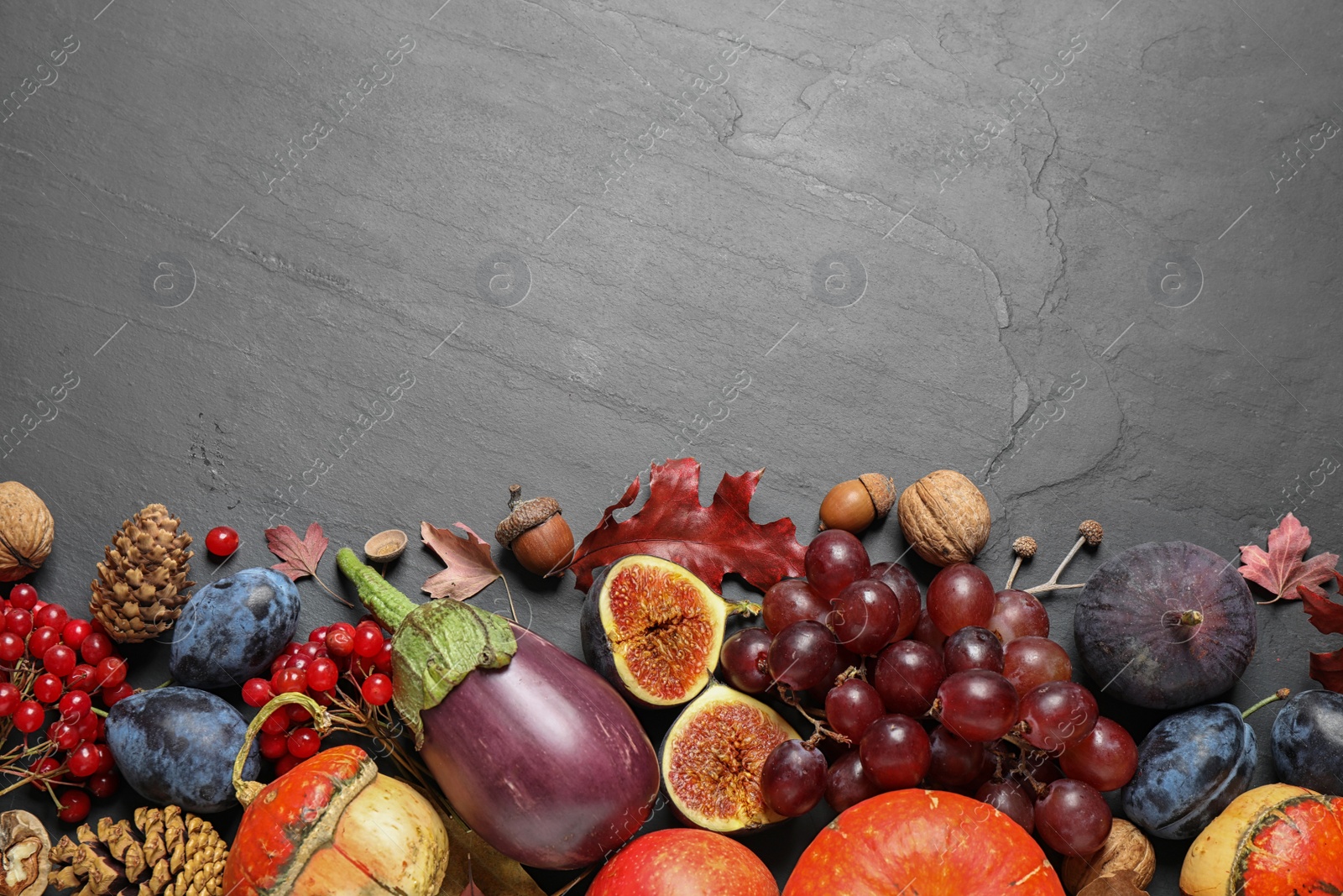 Photo of Flat lay composition with autumn vegetables and fruits on grey background, space for text. Happy Thanksgiving day