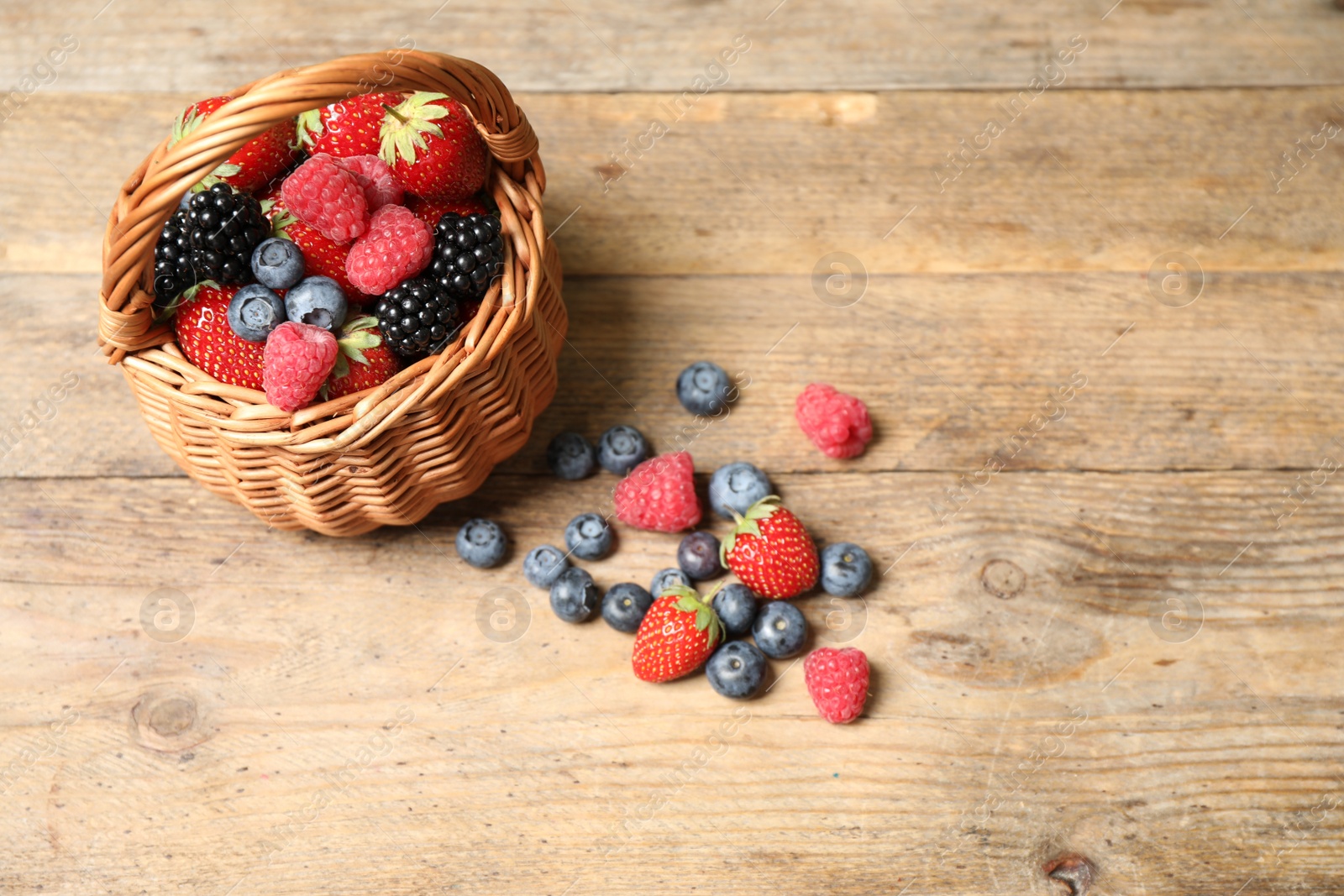 Photo of Mix of ripe berries on wooden table