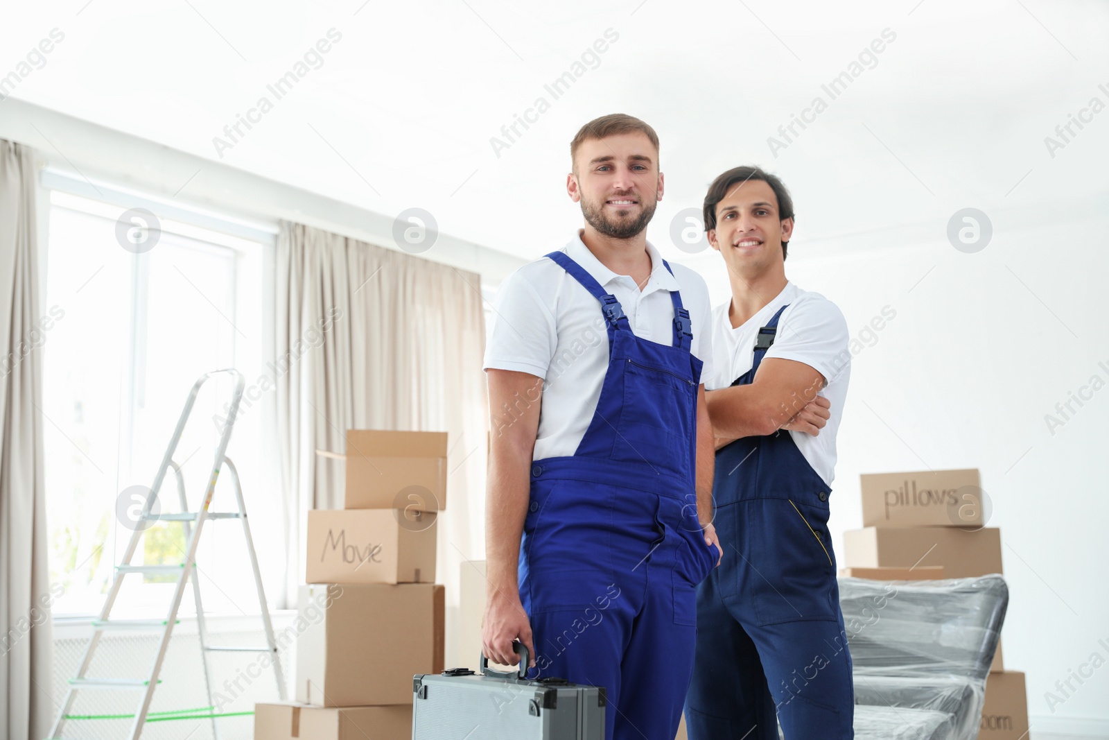 Photo of Portrait of male movers in uniform indoors